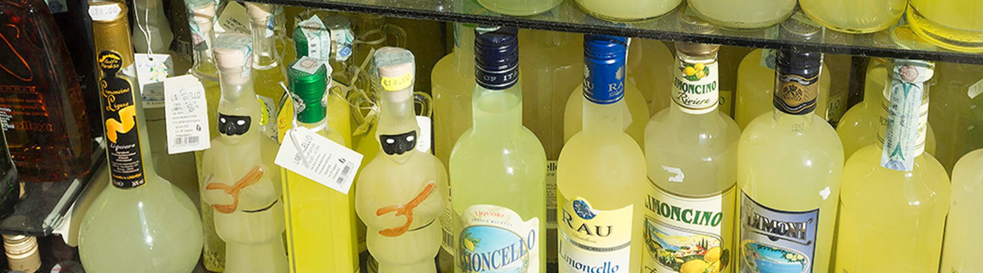 Flessenwand met Italiaanse limoncello en aperitieven in limoncello-geel