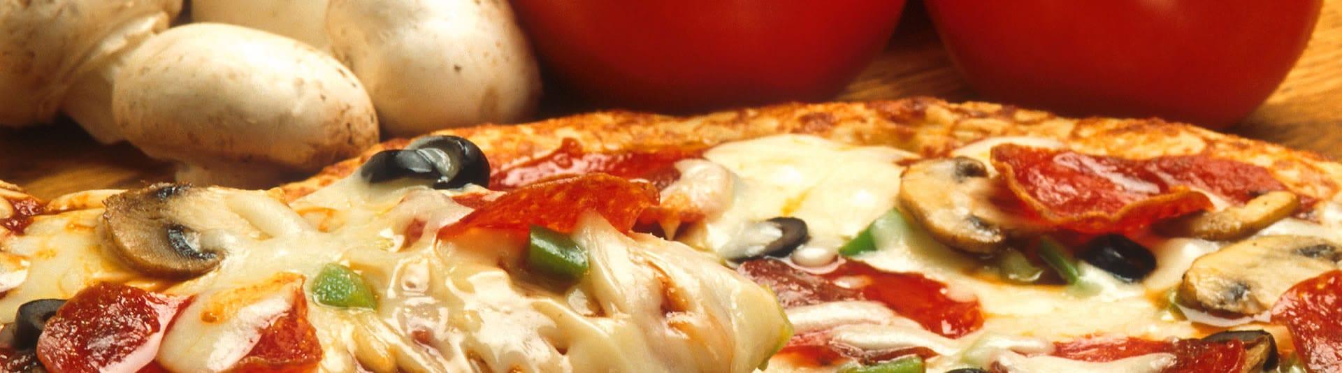 Vers bereide pizza met salami, olijven en champignons uit het dagelijks winkelaanbod